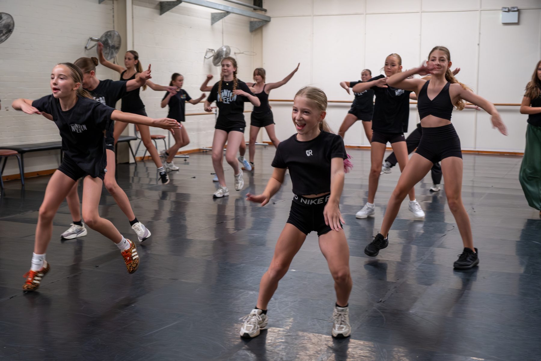 Three Studio 19 dancers mid-routine in a jazz class