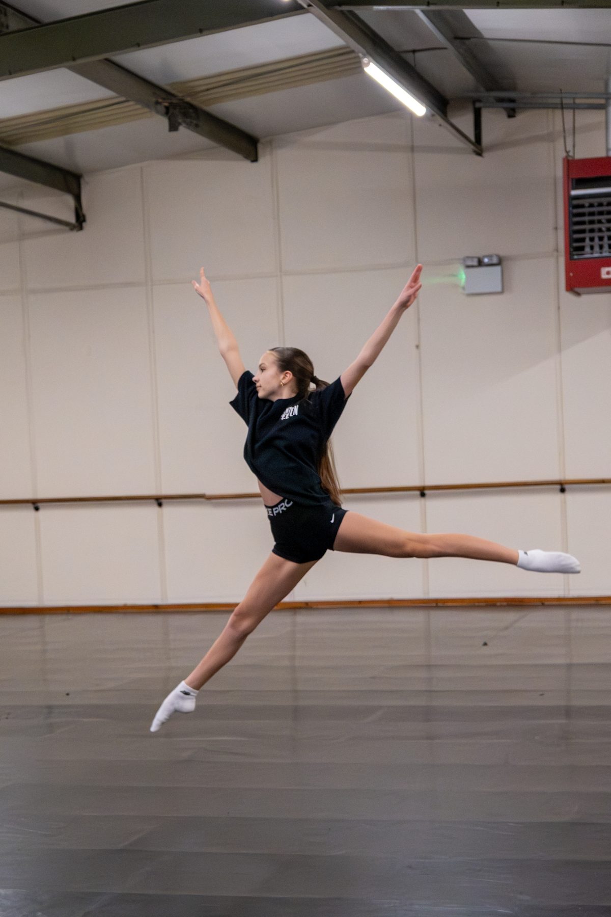 A DC-19 dancer mid-turn, hair flying, in the studio